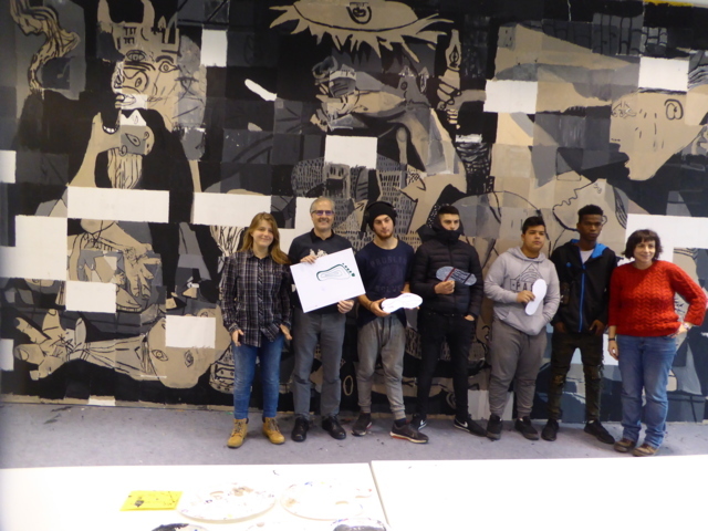 En la imagen un grupo de jóvenes posa satisfecho ante el mural colaborativo llevado a cabo en el proyecto Gernika