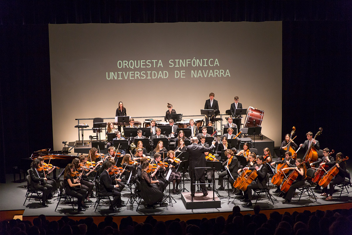 en la imagen los miembros de la orquesta sinfónica Universidad de Navarra tocan una pieza bajo la direccion de Borja Quintas. 