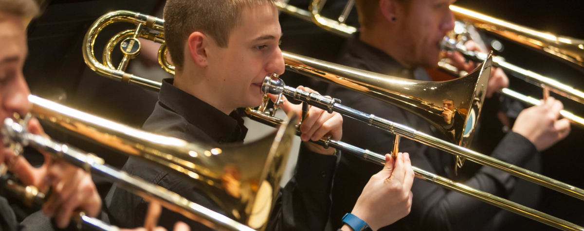 En la fotografía, la sección de viento de la orquesta Universidad de Navarra. Varios trombones tocan una pieza bajo la dirección de Borja Quintas